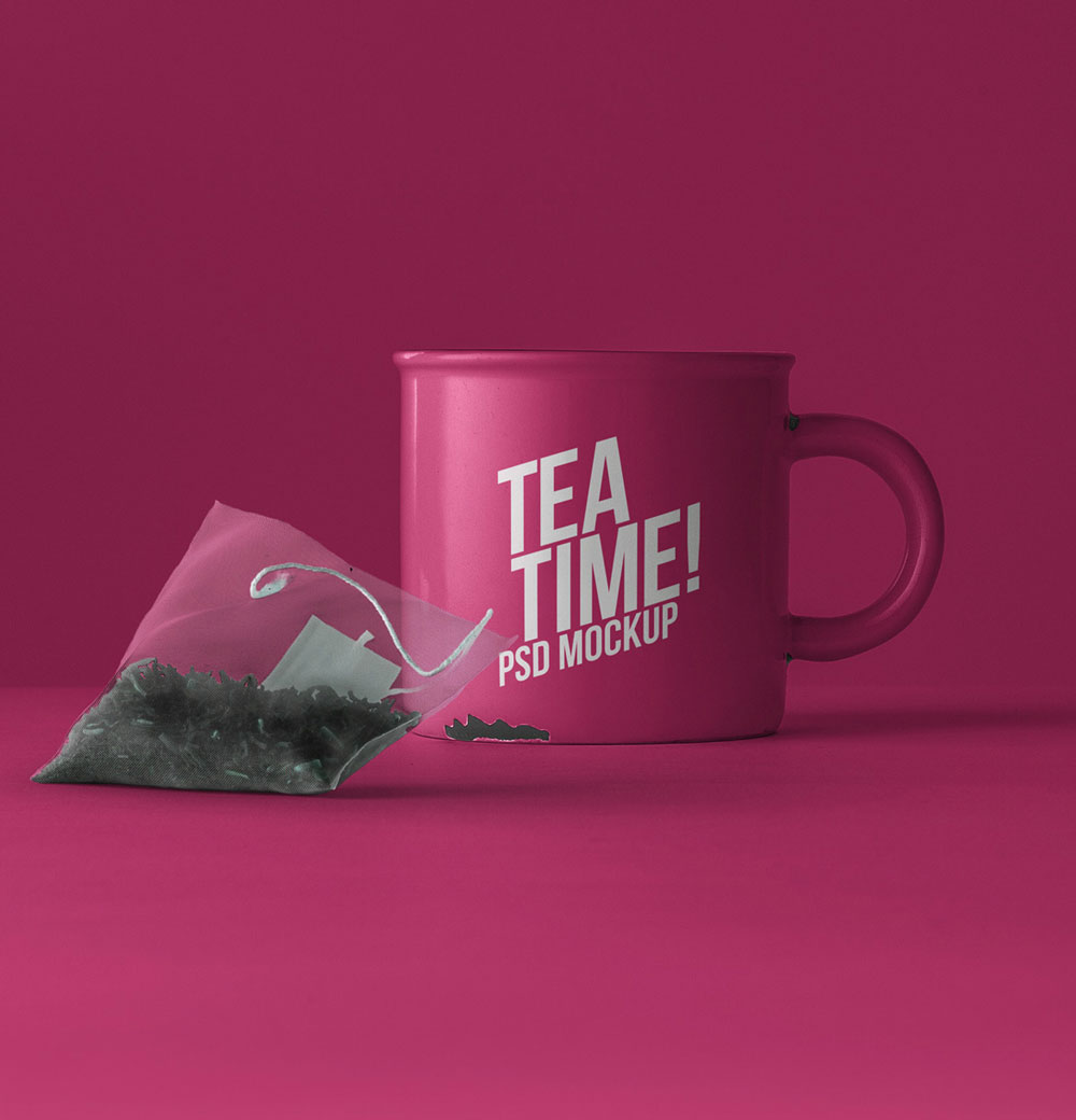 Pink tea mug with 'TEA TIME! PSD MOCKUP' text, next to a tea bag filled with loose leaf tea, on a vibrant pink background.